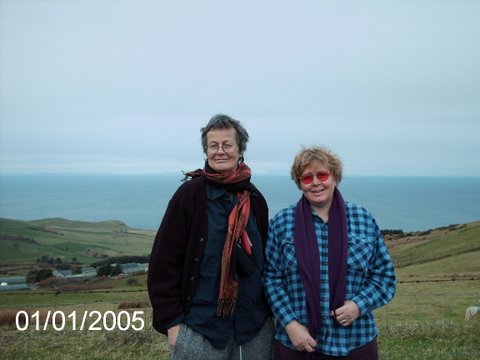 Un portrait dans un paysage: les deux ont l’air joyeux sur fond de mer brumeuse et de collines vallonnées.
