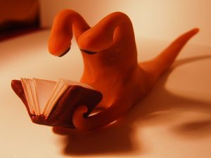 Sculpture of a slug-like creature reading a book