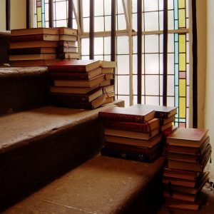 A barely-relevant photo: piles of books on stairs by a window.